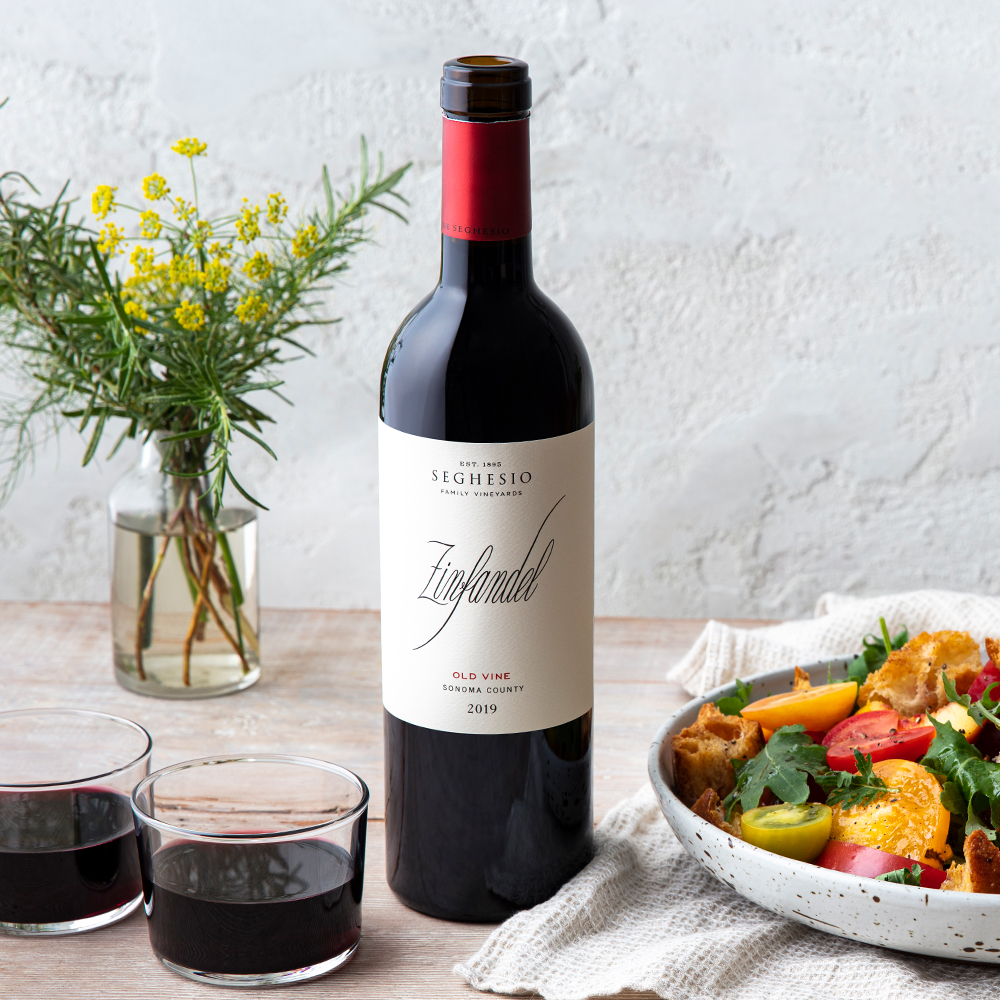 2019 Old Vine Zinfandel bottle on table with wine glasses and food